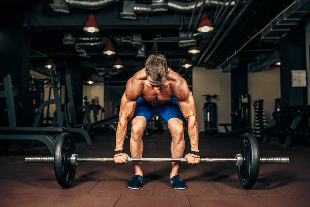 Young shirtless man doing deadlift exercise at gym. motivation. - 写真・画像