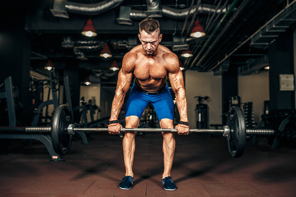 Young shirtless man doing deadlift exercise at gym. motivation. - 写真・画像
