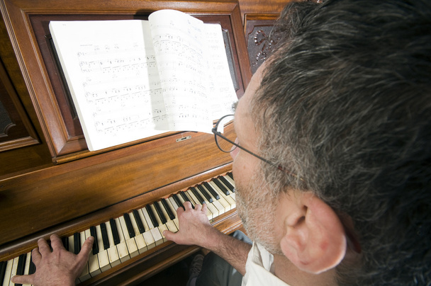 älterer Mann mittleren Alters spielt Klavier - Foto, Bild