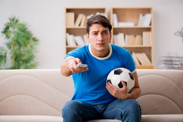 Мужчина смотрит футбол дома
 - Фото, изображение