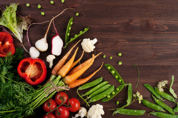 チェリー トマト、赤唐辛子、若い緑豆、茶色の木製の背景に大根と野菜背景 (壁紙)。ベジタリアン、ビーガンの概念。テキストのためのスペース - 写真・画像