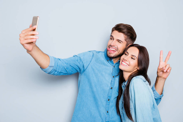 Portrait of two happy lovers making selfie on smartphone - Photo, image