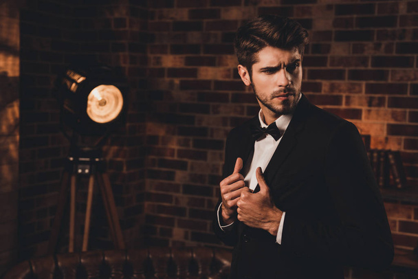 Portrait of sexy macho man wearing black tuxedo and bow-tie in l - Zdjęcie, obraz