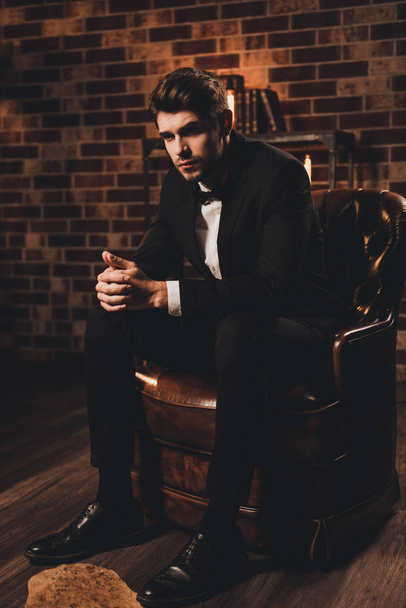 Portrait of successful businessman in tuxedo sitting in luxury l - Fotografie, Obrázek
