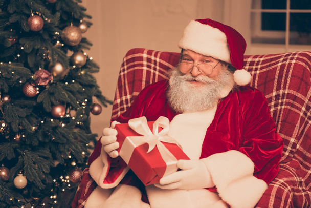 Happy old Santa in red costume holding xmas present - Foto, Bild