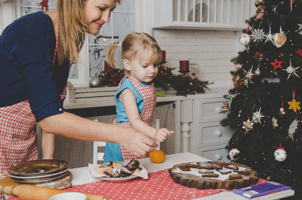 Happy mother and little daughter making cookies on kitchen  - Photo, Image