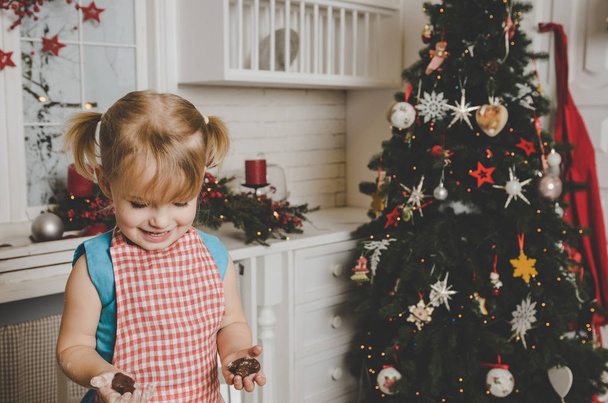 Happy little girl making cookies on kitchen  - Valokuva, kuva