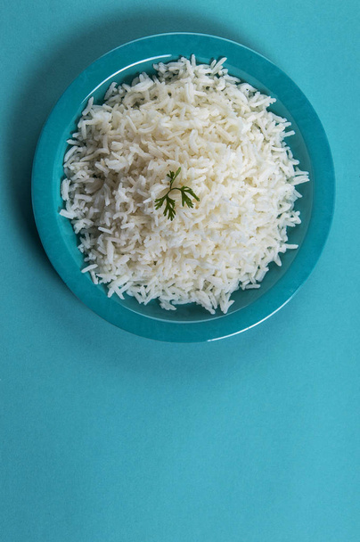 Cooked plain white basmati rice with corriander in a blue plate on blue background - Foto, Bild