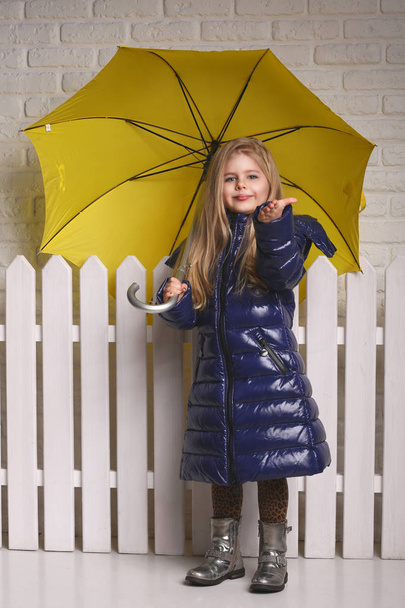 Little lady with umbrella near the fence. Close up. White background - Foto, Bild