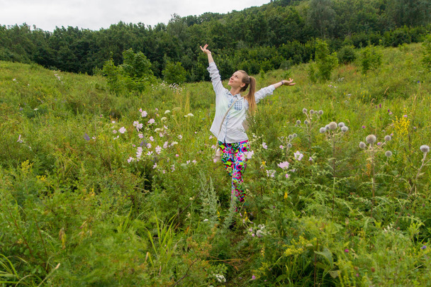 Giovane ragazza che si gode la natura tra i fiori selvatici in una foresta
 - Foto, immagini
