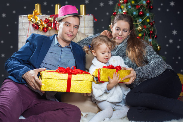 Young family posing on the background of Christmas - Foto, Imagem
