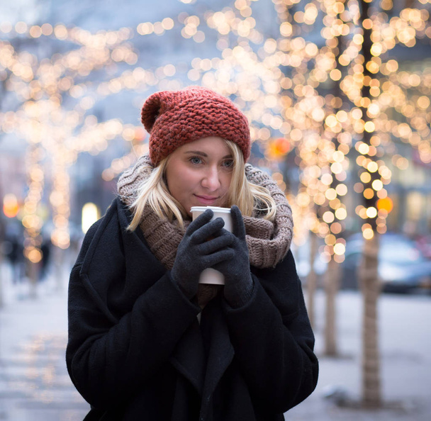 Jonge aantrekkelijke vrouw met een koffiekopje in een winterdag - Foto, afbeelding