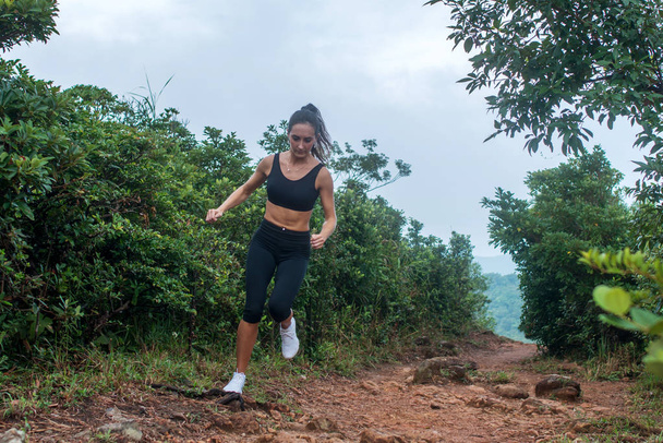 Metsäpolulla juokseva naisurheilija
  - Valokuva, kuva