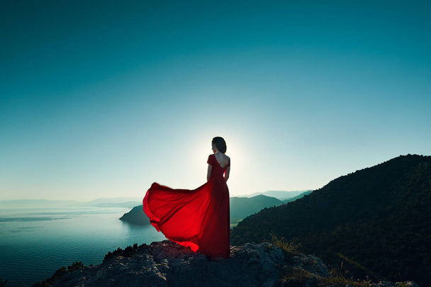 Woman in red dress by sea - Foto, Bild