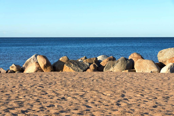 sandy beach and big stones ashore near water - Photo, Image