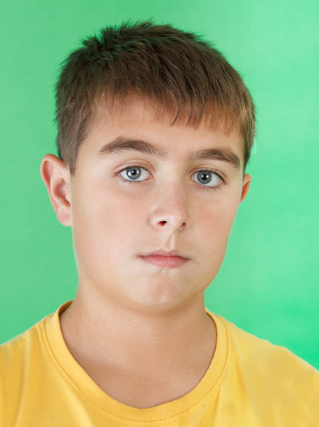 Studio portrait of young boy on green background - Photo, Image