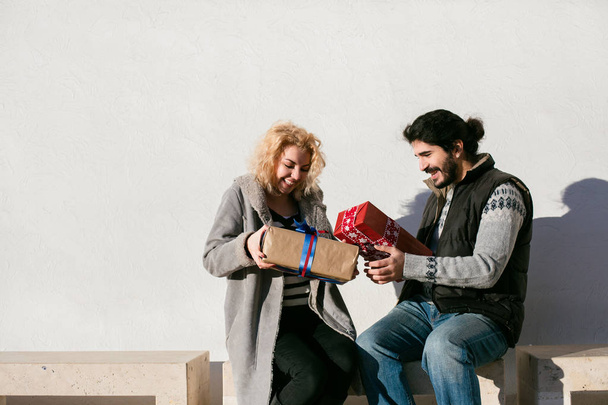 cheerful couple exchanging gifts - Фото, изображение