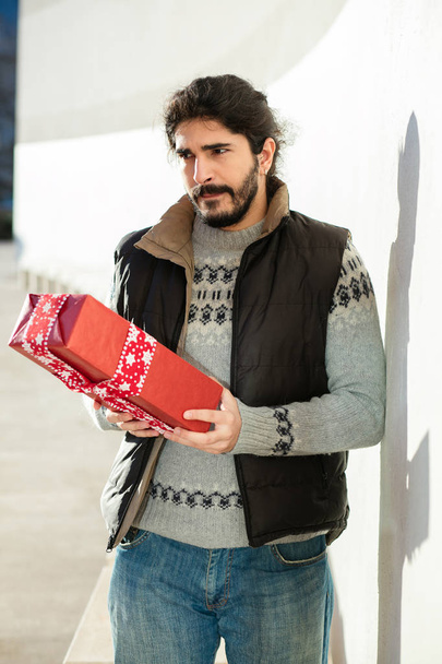 Young man with red gift concept - Φωτογραφία, εικόνα
