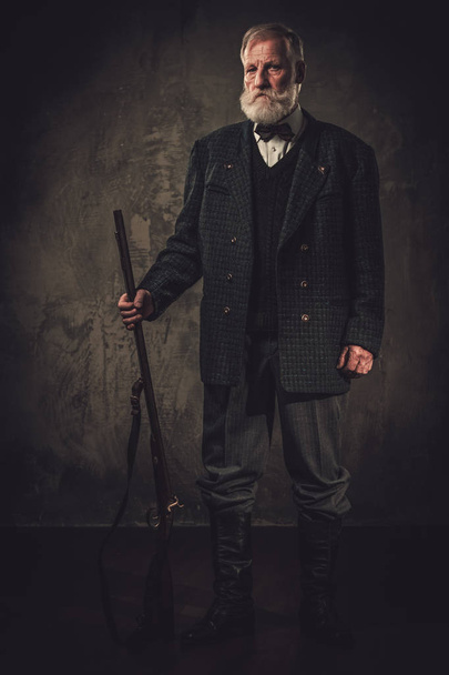 Senior hunter with a shotgun in a traditional shooting clothing - Fotografie, Obrázek