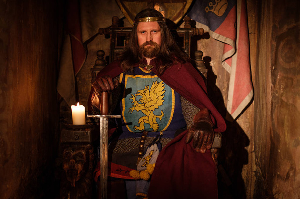 Средневековый король на троне в интерьере древнего замка
. - Фото, изображение