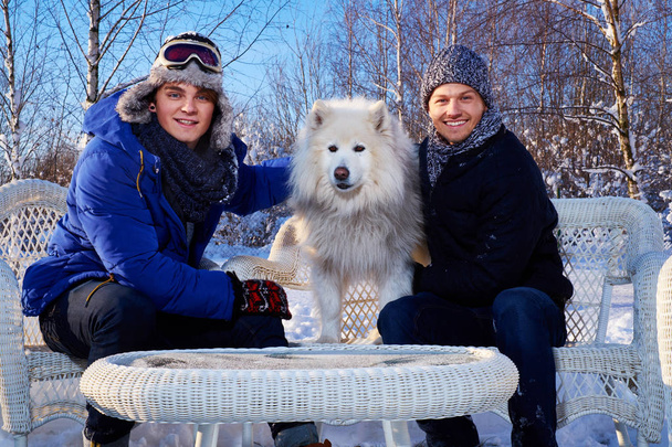 Dos amigos con perro pasan vacaciones de invierno juntos
  - Foto, Imagen