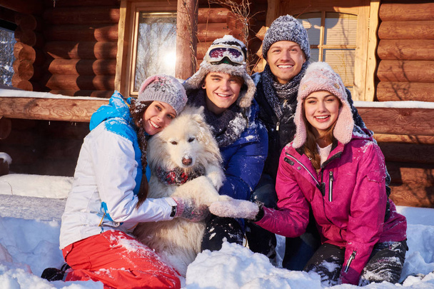 Веселые друзья с собакой проводят зимние каникулы вместе
  - Фото, изображение