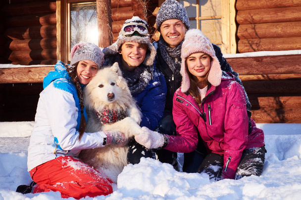 Cheerful friends with dog spend winter holidays together  - Photo, Image