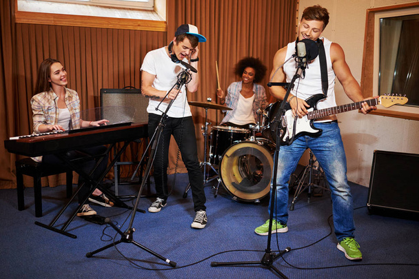 multirassische Musikband tritt in einem Tonstudio auf - Foto, Bild