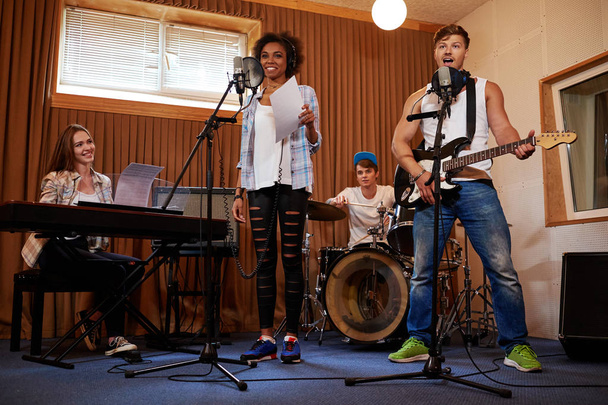 Multiracial music band performing in a recording studio - Foto, afbeelding