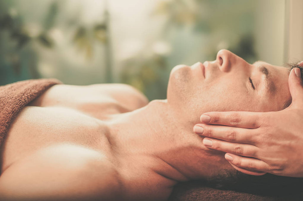 Handsome man having massage in spa salon - Photo, Image