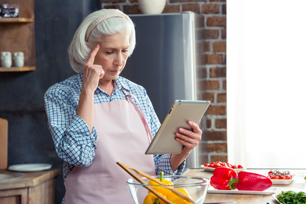 Vrouw met digitale tablet in de keuken - Foto, afbeelding