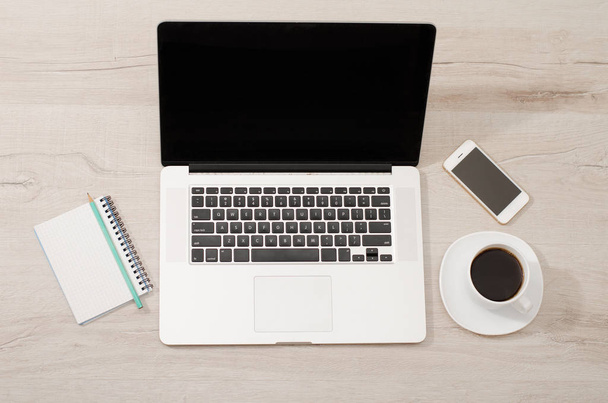 Vista superior de um laptop, telefone inteligente, um notebook com um lápis e uma xícara de café
 - Foto, Imagem
