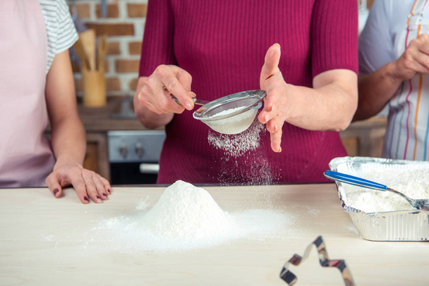 Woman sifting flour  - Zdjęcie, obraz