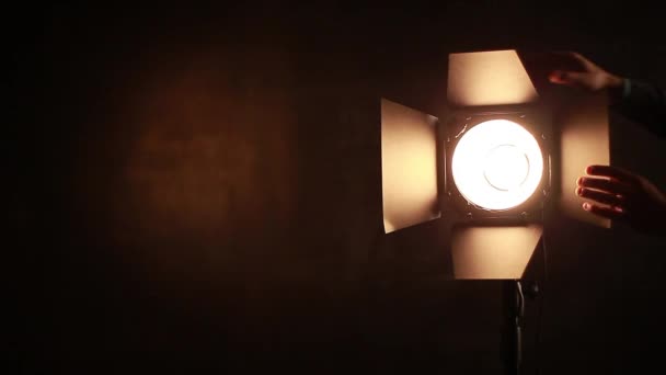 Photographe ajuste l'équipement d'éclairage sur un fond de tableau
 - Séquence, vidéo