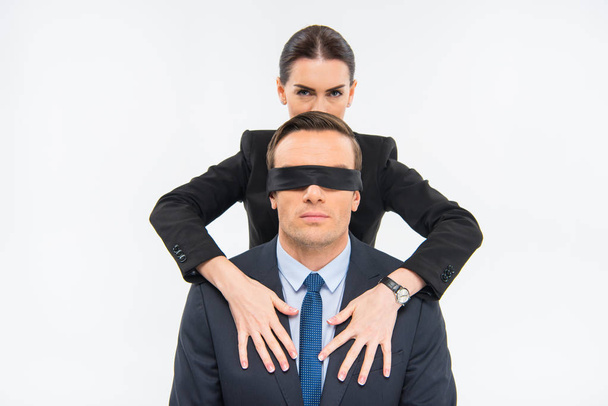 Бизнесмен в повязке на глаза и деловая женщина
 - Фото, изображение