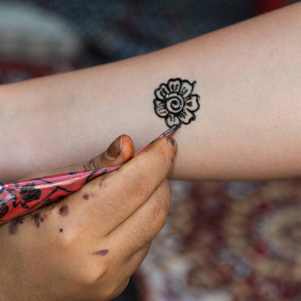 Drawing Floral Henna Tatoo on Female Arm - Valokuva, kuva