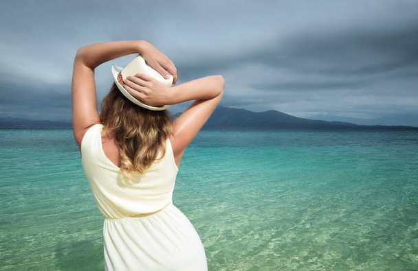 Hermosa mujer con vestido blanco en una playa en el fondo de
  - Foto, Imagen