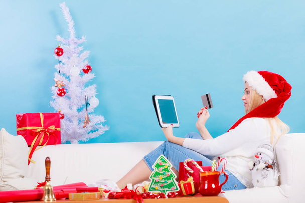 Nő a Santa kalap tabletta és hitelkártya - Fotó, kép