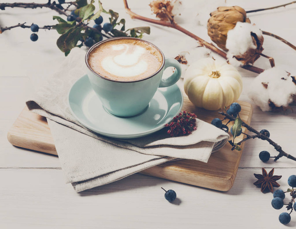 Latte de especiarias de abóbora. xícara de café no fundo de madeira branca
 - Foto, Imagem