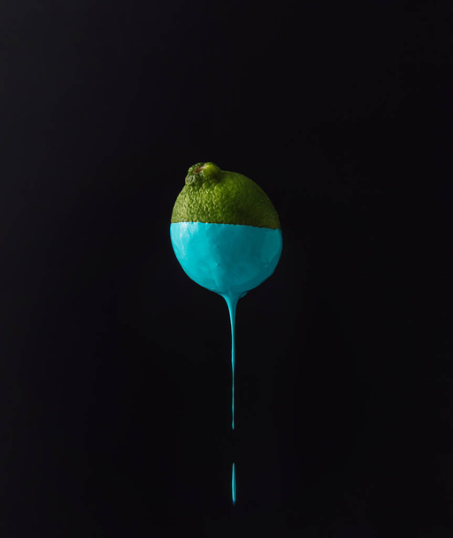 Lime with dripping blue paint  - Valokuva, kuva