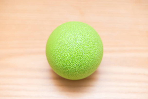 verde pequeña bola de masaje en una mesa de madera
 - Foto, imagen