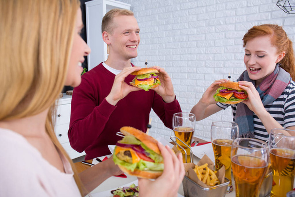 Man and women eating burgers - Foto, immagini