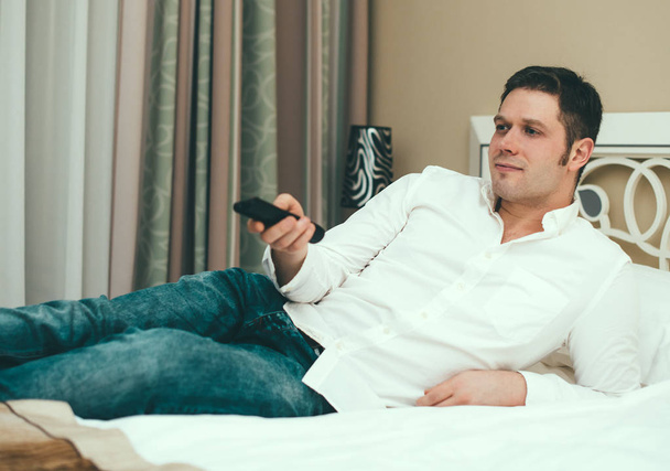 Man watching TV in hotel room. - Foto, afbeelding
