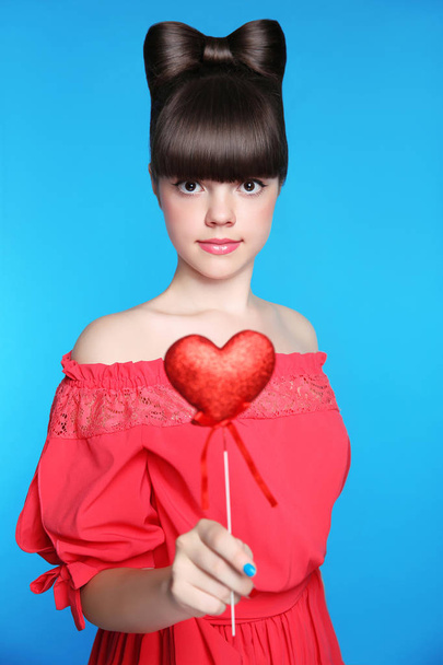 Smiling teen girl with bow hair style, brunette young model hold - 写真・画像