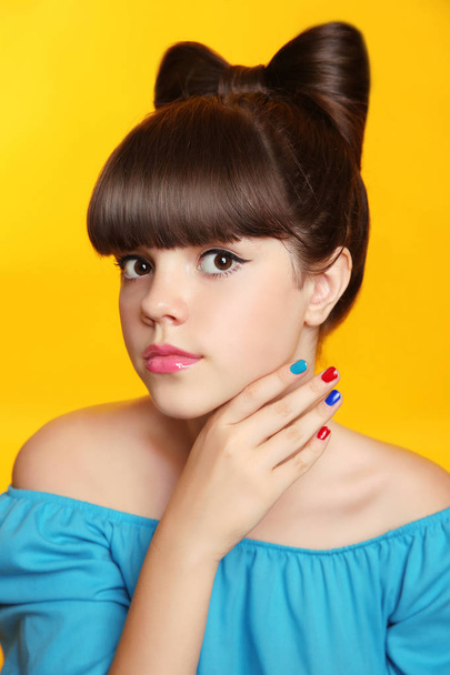 Beautiful smiling teen girl with bow hairstyle, makeup and colou - Foto, afbeelding