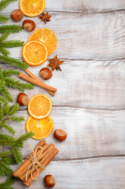 Christmas background with fir branches, spices, nuts and slices of dried orange. - 写真・画像