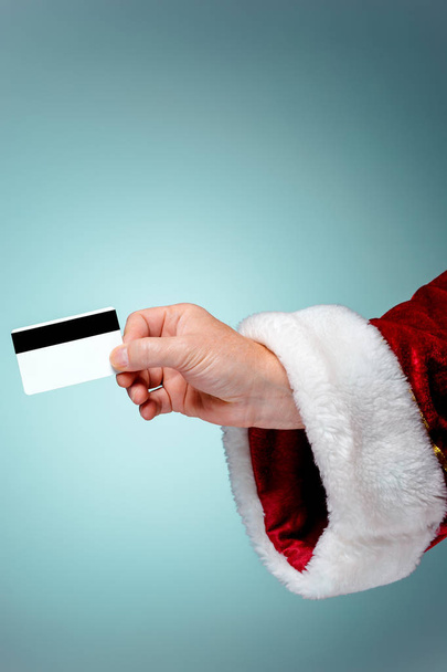 Santa Claus hand holding a credit card - Foto, afbeelding