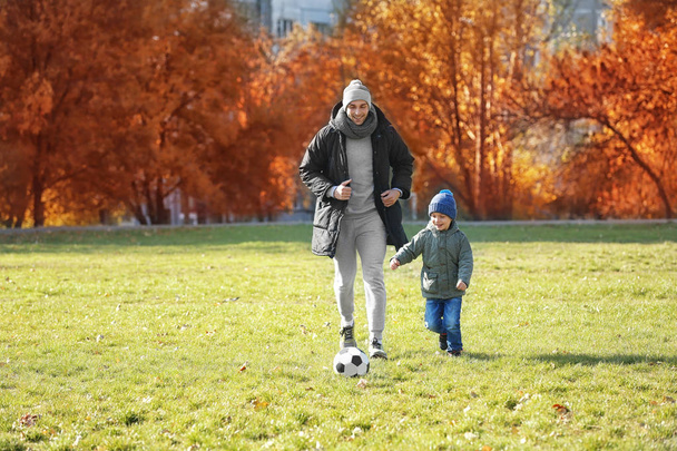 Father and son playing football - Foto, afbeelding
