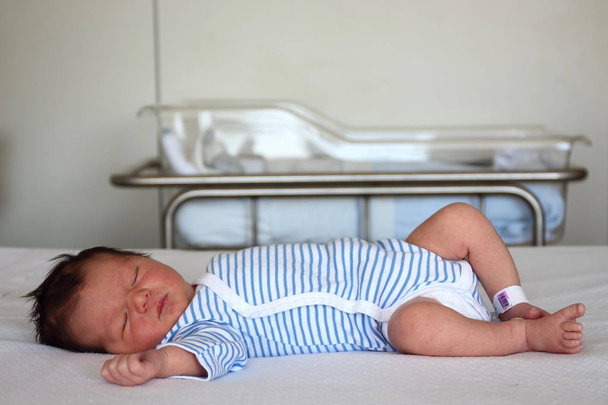 Γλυκό νεογέννητο μωράκι ξαπλωμένη στο κρεβάτι μόλις δύο ημέρες μετά την άφιξη - Φωτογραφία, εικόνα