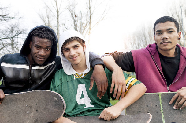 group of young adults sitting on a ramp with skateboard - Fotoğraf, Görsel